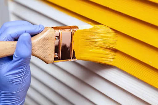 Brushing bright paint on shutters in Manhattan Beach